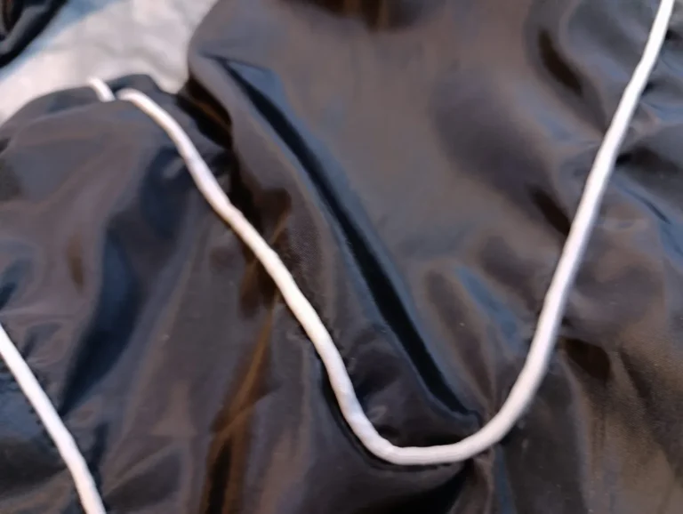 Close-up of white piping detail on black track pants – made by Naxon Sports