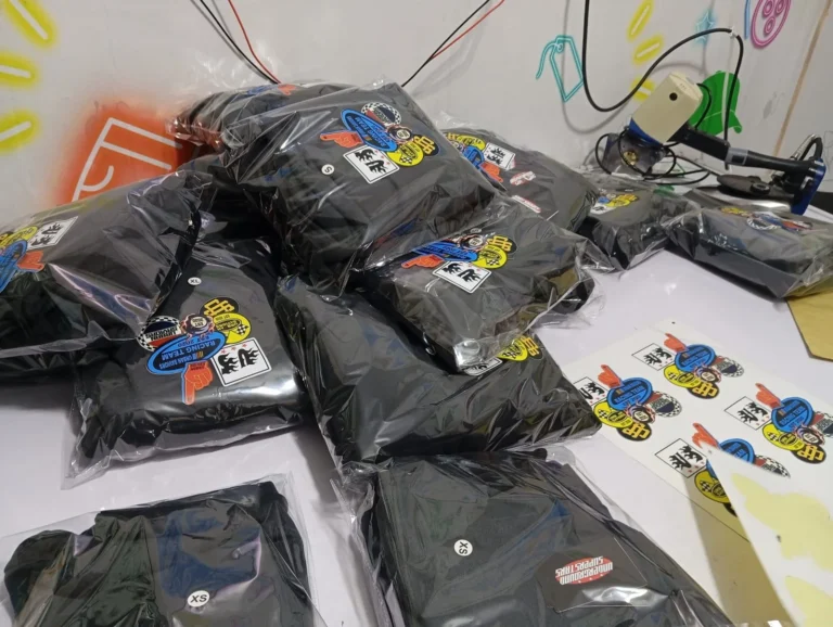 Custom black printed garments with stickers and packaging – made by Naxon Sports