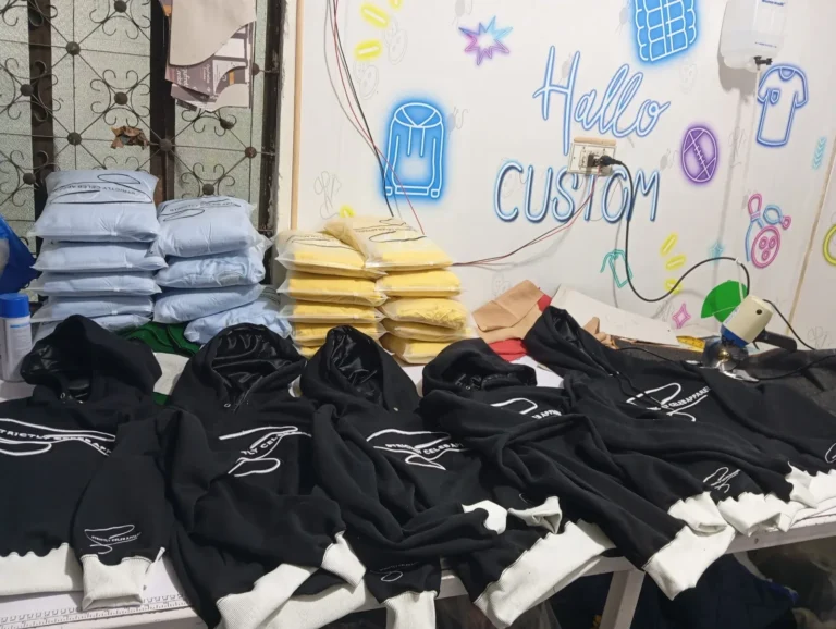 Custom black tracksuits laid out on the production table – made by Naxon Sports