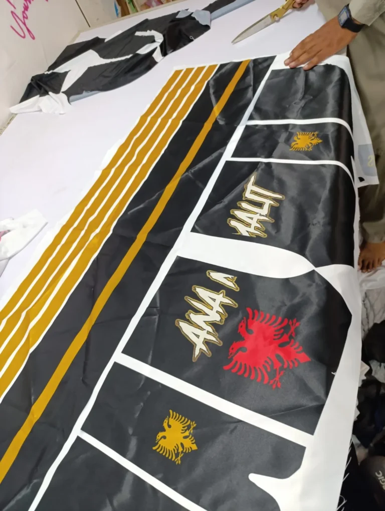 Cut tracksuit panels with gold stripes and printed logos before stitching – made by Naxon Sports