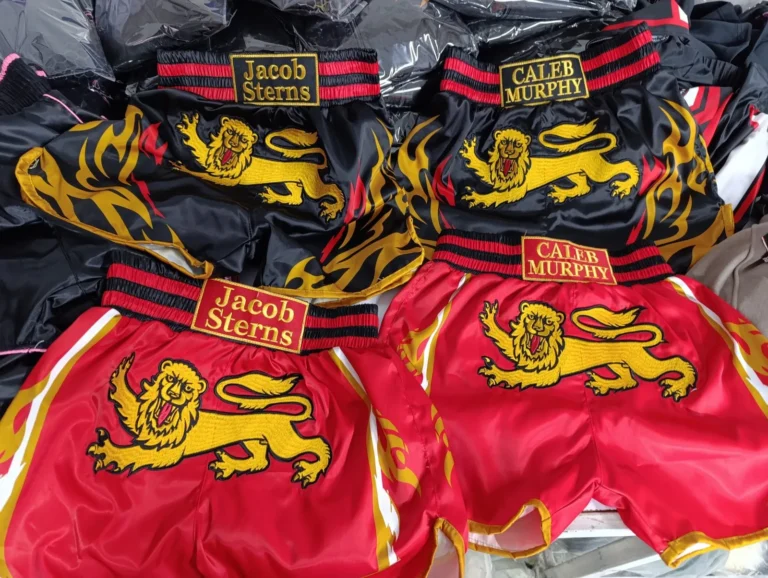 Red and gold custom Muay Thai shorts with lion print – made by Naxon Sports