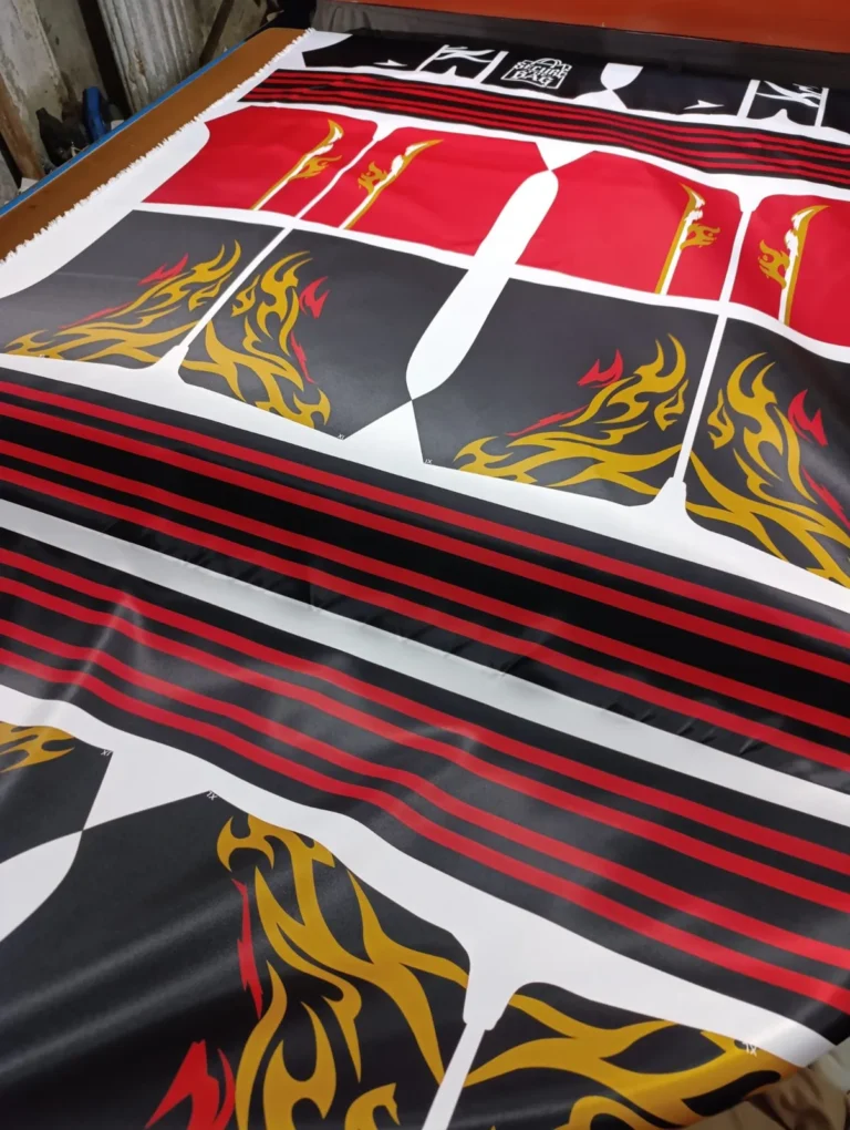 Sublimation-printed fabric panels in red and gold before stitching – made by Naxon Sports